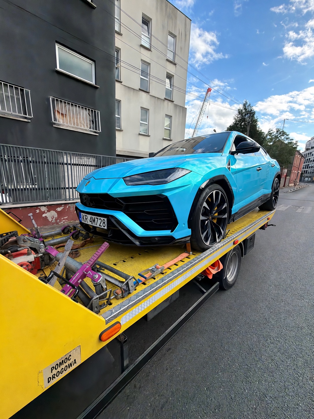 Turkusowy SUV zabezpieczony na żółtej lawecie